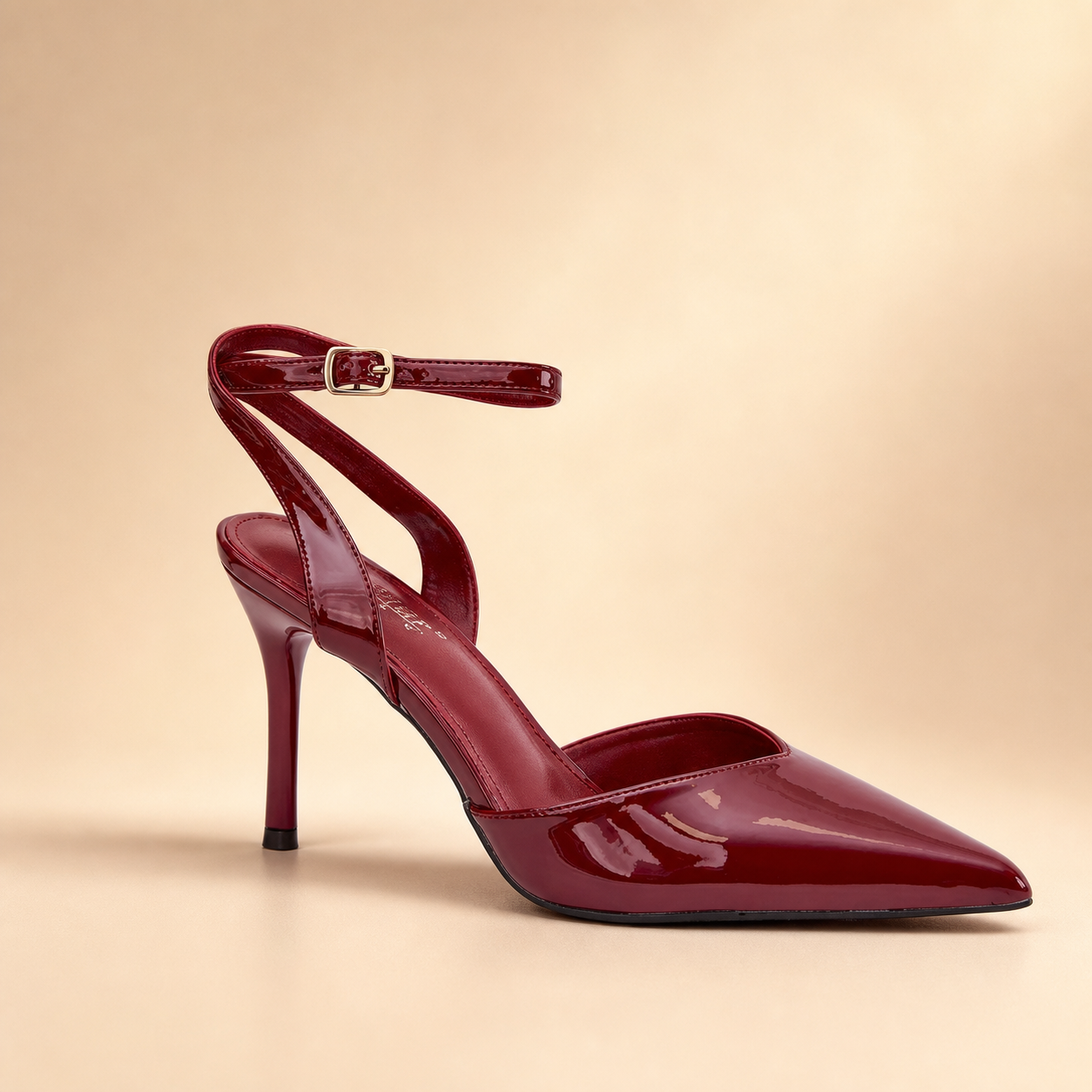 Burgundy patent pointed-toe stiletto heel with cross straps and gold-tone buckle